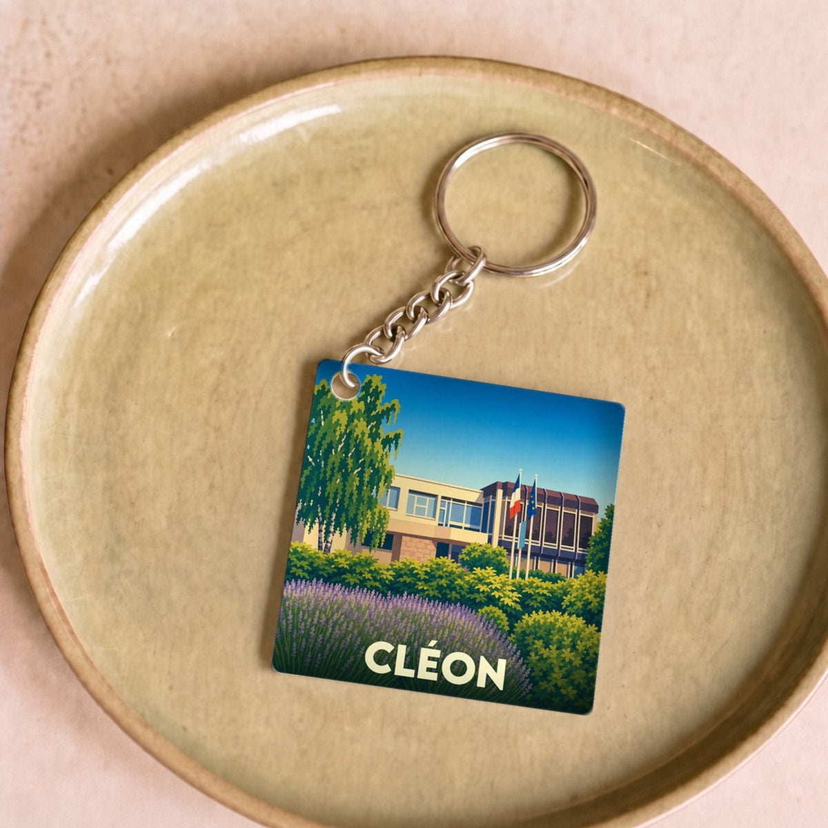 Porte-clés souvenir de la ville de Cléon avec une illustration stylisée.