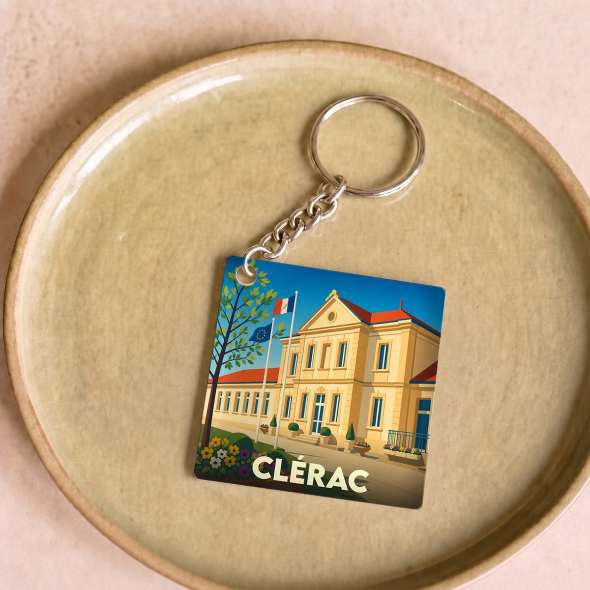 Porte-clés souvenir de la ville de Clérac avec une illustration stylisée de la mairie.