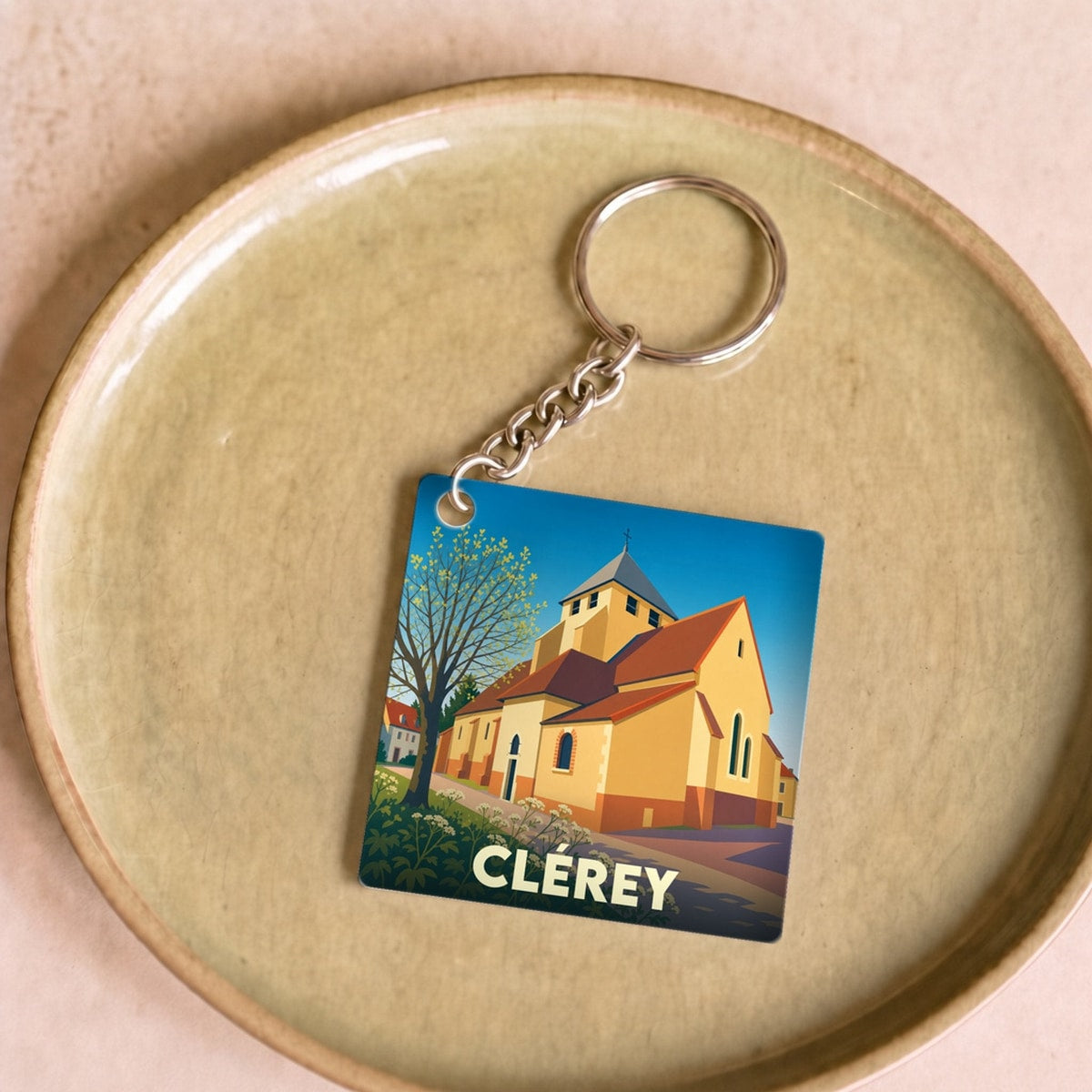 Porte-clés souvenir de la ville de Clérey avec une illustration stylisée de son église.