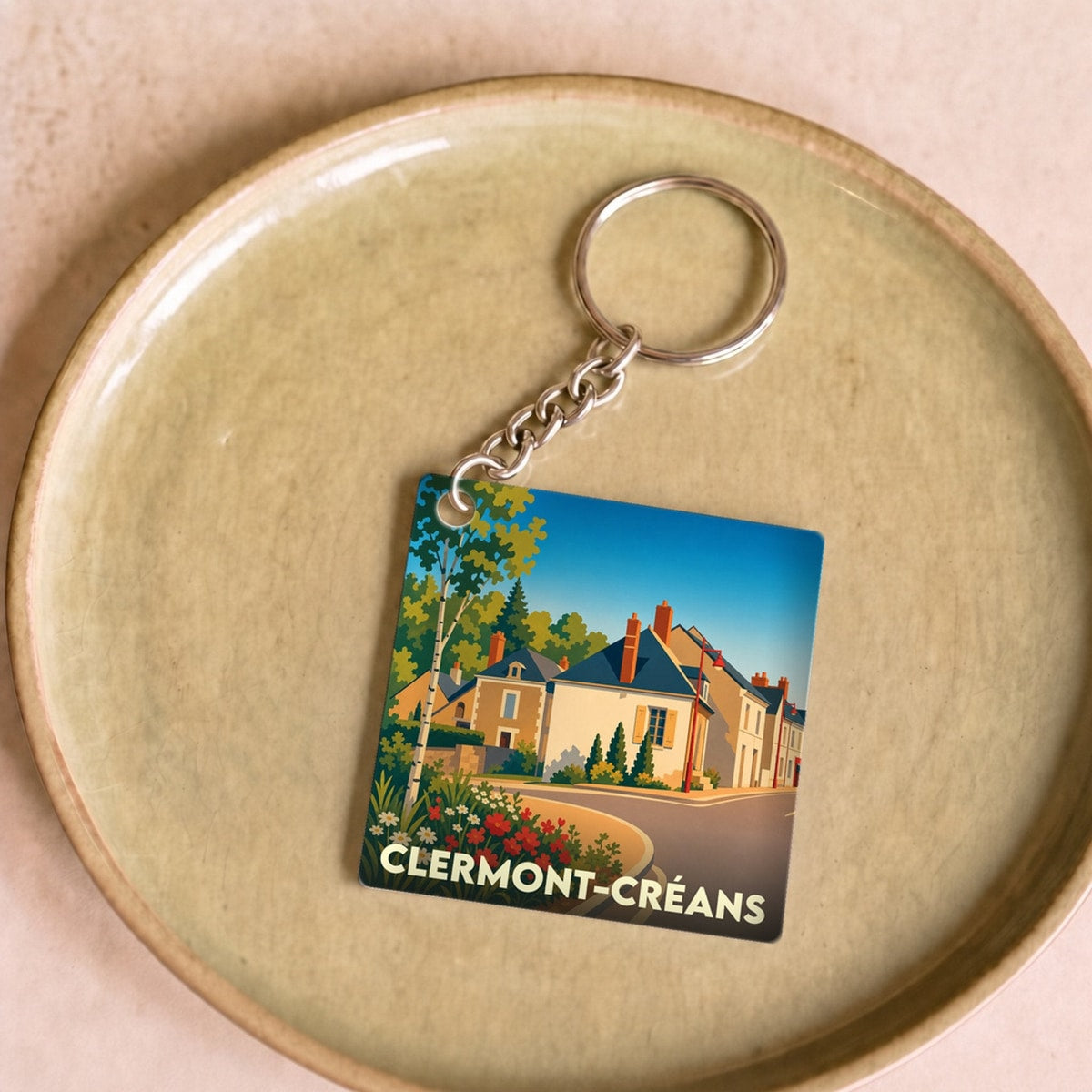 Porte-clés souvenir de Clermont-Créans avec une illustration colorée et stylisée de la ville.