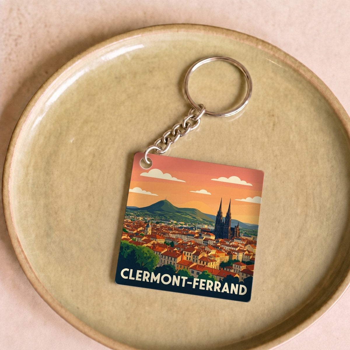 Porte-clés souvenir de la ville de Clermont-Ferrand avec une illustration stylisée.
