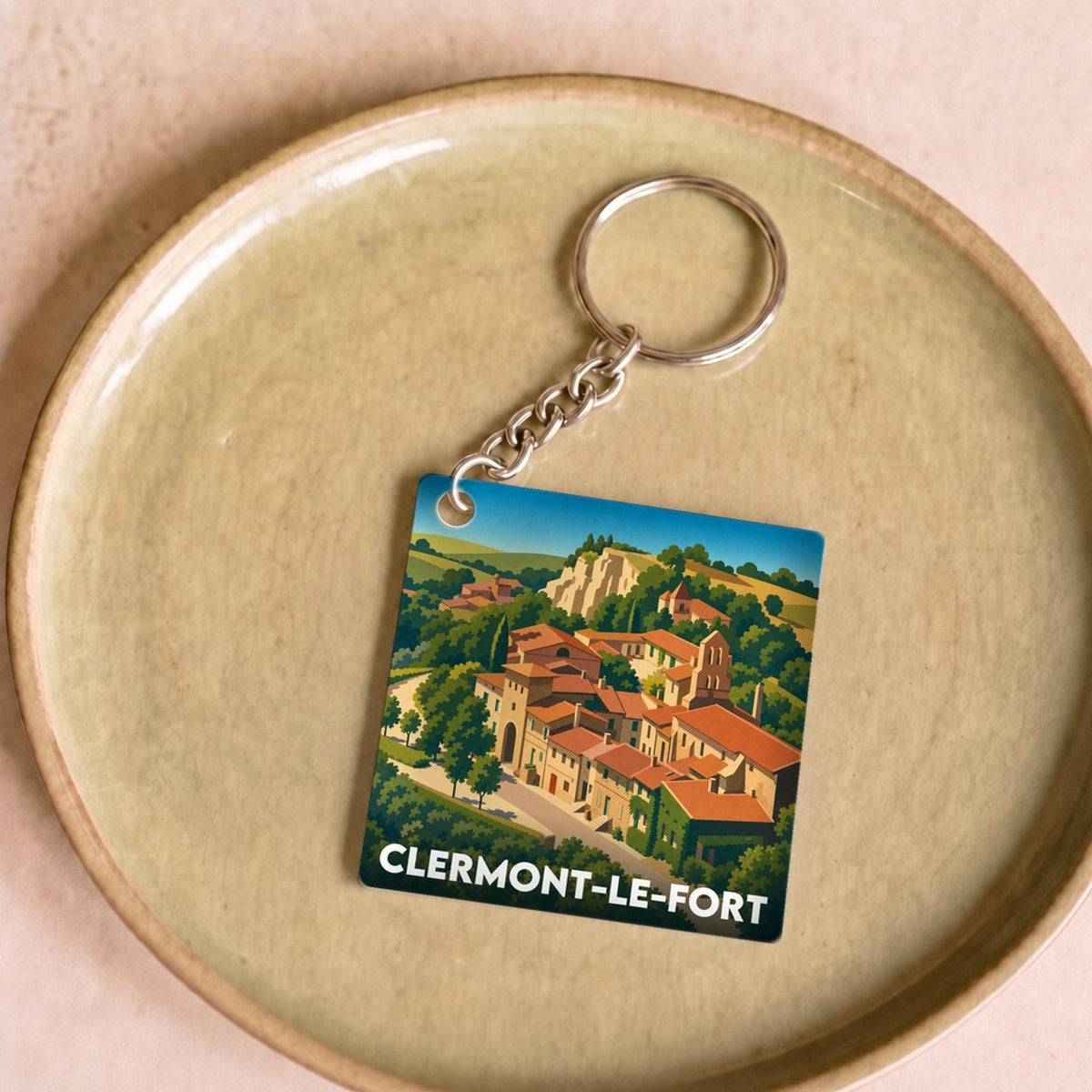 Porte-clés souvenir de la ville de Clermont-le-Fort avec une illustration stylisée du village.