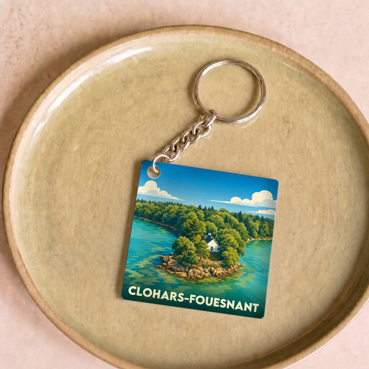 Porte-clés souvenir de la ville de Clohars-Fouesnant avec une illustration stylisée d'un paysage côtier breton.