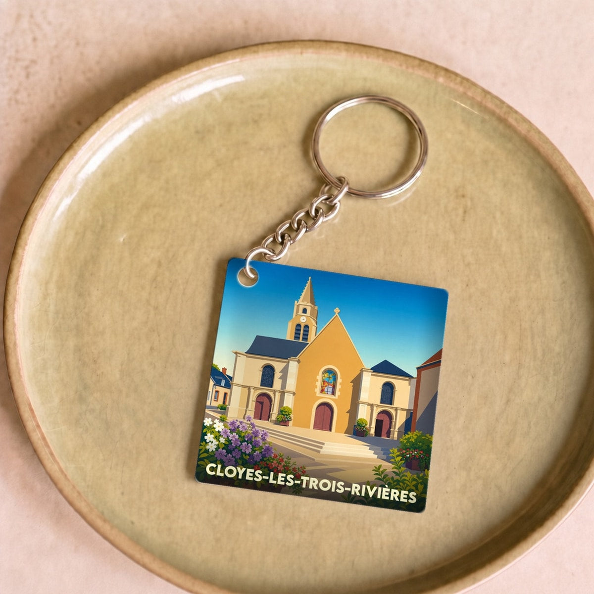 Porte-clés souvenir de la ville de Cloyes-les-Trois-Rivières avec une illustration stylisée de son église.