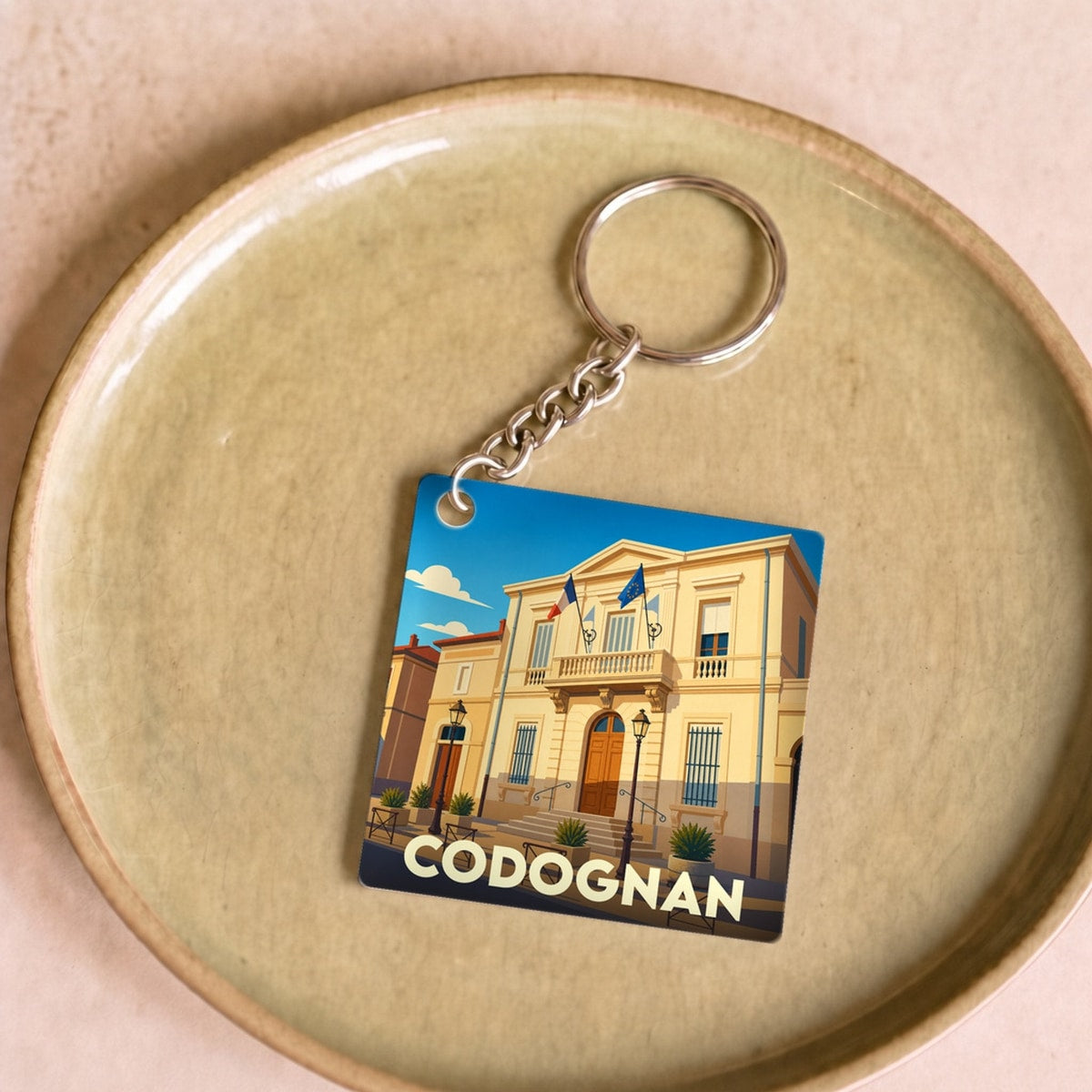 Porte-clés souvenir de la ville de Codognan avec une illustration stylisée de sa mairie.