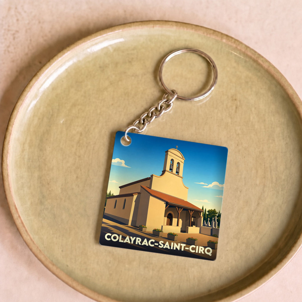 Porte-clés souvenir de la ville de Colayrac-Saint-Cirq avec une illustration stylisée d'une église.