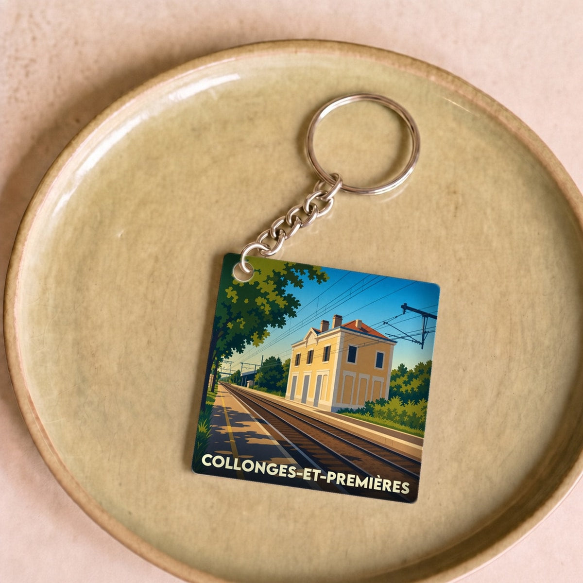 Porte-clés souvenir de la ville de Collonges-et-Premières avec une illustration stylisée de sa gare ferroviaire.