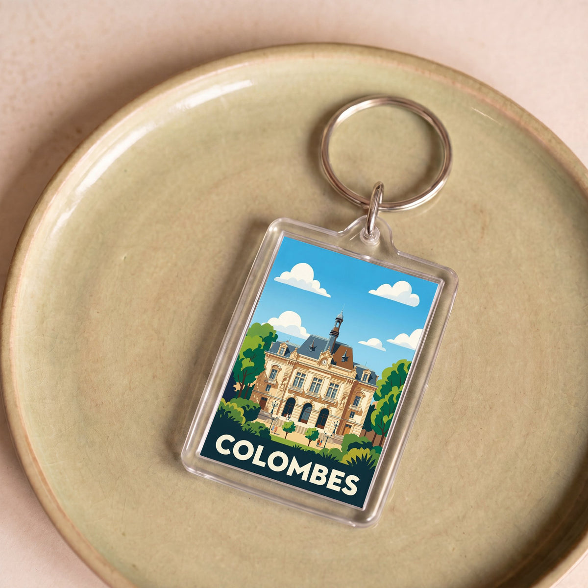 Porte-clés souvenir de la ville de Colombes avec une illustration stylisée.