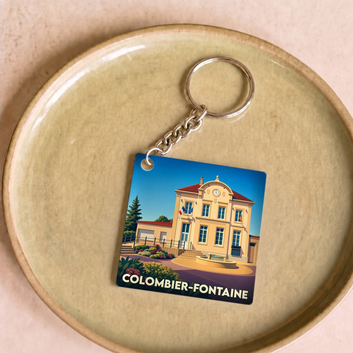 Porte-clés souvenir de la ville de Colombier-Fontaine avec une illustration stylisée de sa mairie.