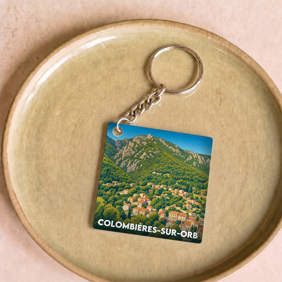 Porte-clés souvenir de la ville de Colombières-sur-Orb avec une illustration stylisée.