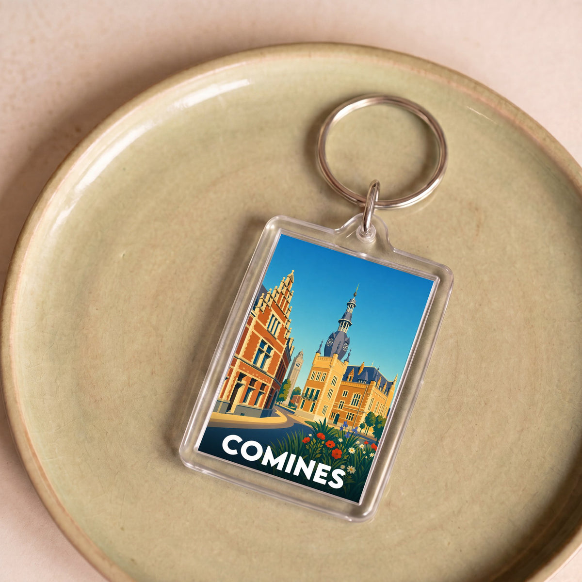 Porte-clés souvenir de la ville de Comines avec une illustration stylisée.