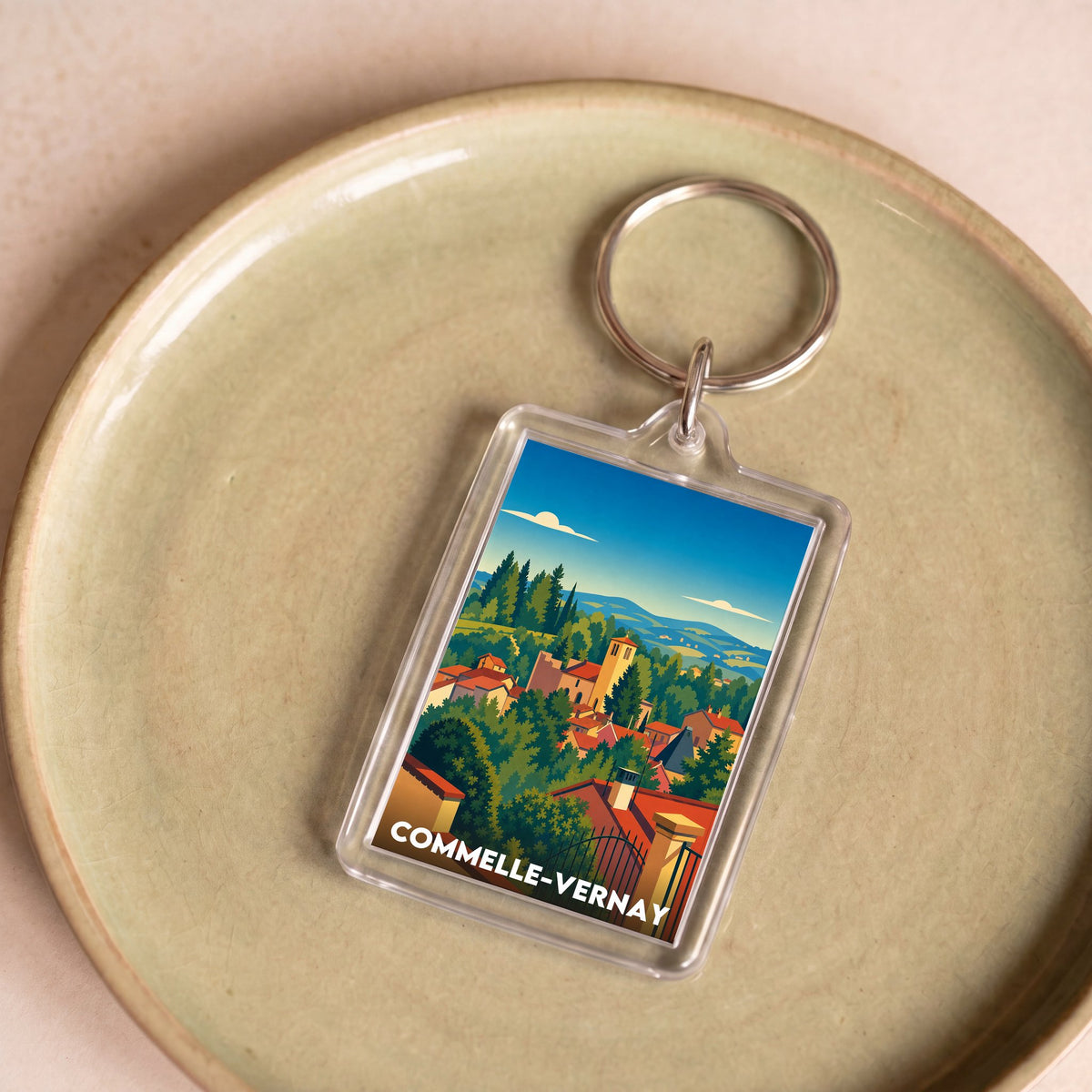 Porte-clés souvenir de la ville de Commelle-Vernay avec une illustration stylisée.