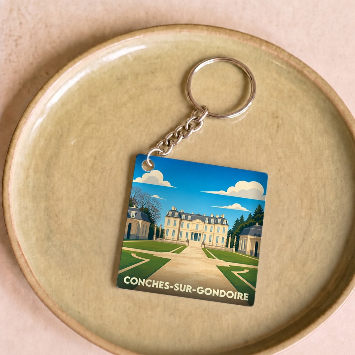 Porte-clés souvenir de la ville de Conches-sur-Gondoire avec une illustration stylisée de son château.