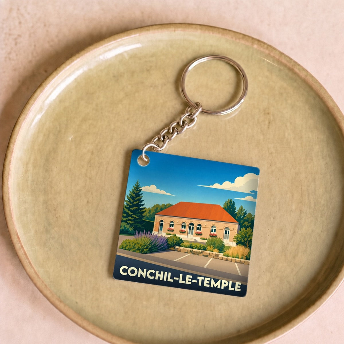 Porte-clés souvenir de la ville de Conchil-le-Temple avec une illustration stylisée.