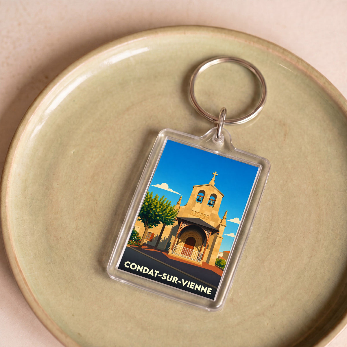 Porte-clés souvenir de la ville de Condat-sur-Vienne avec une illustration stylisée de son église.