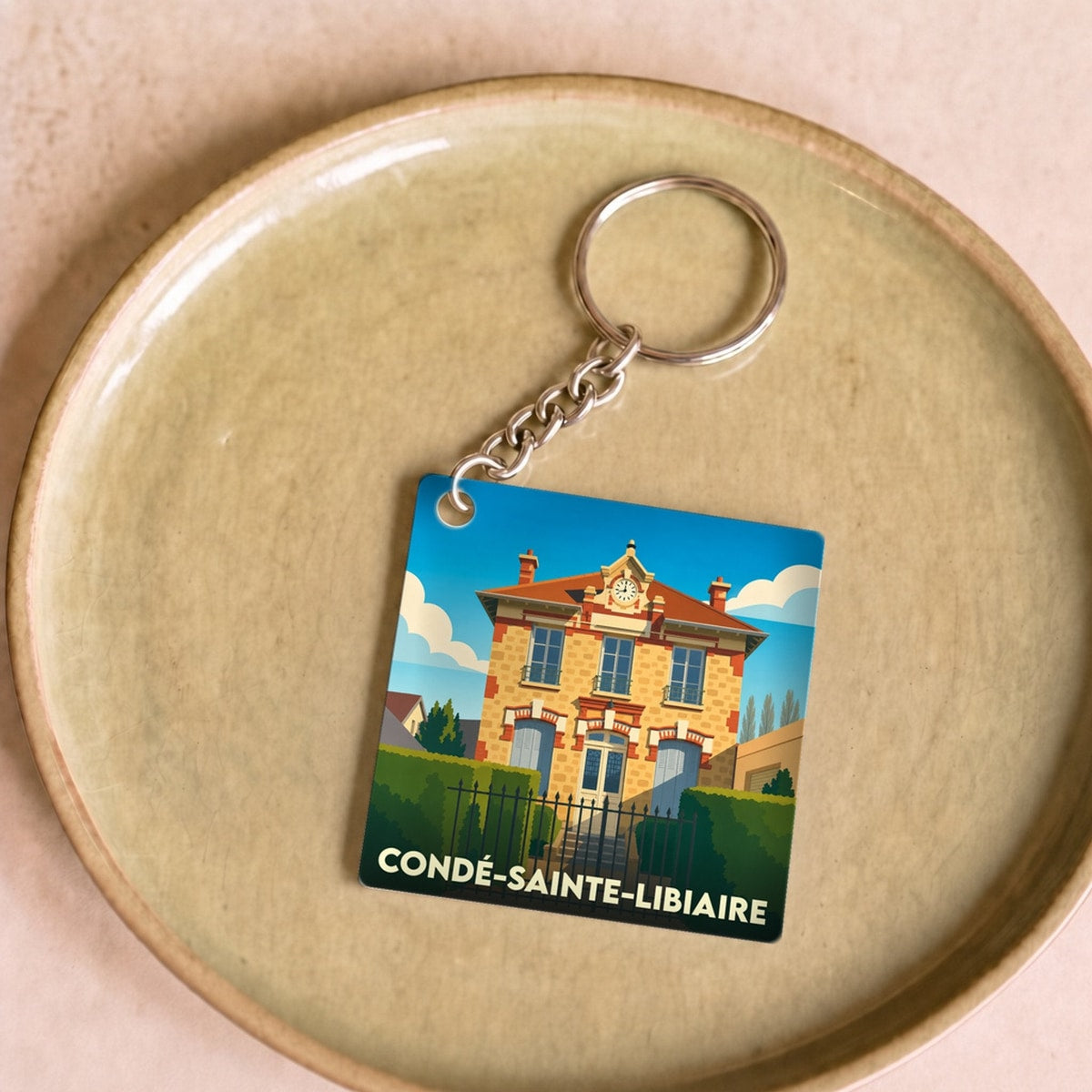 Porte-clés souvenir de la ville de Condé-Sainte-Libiaire avec une illustration stylisée d'un bâtiment historique.