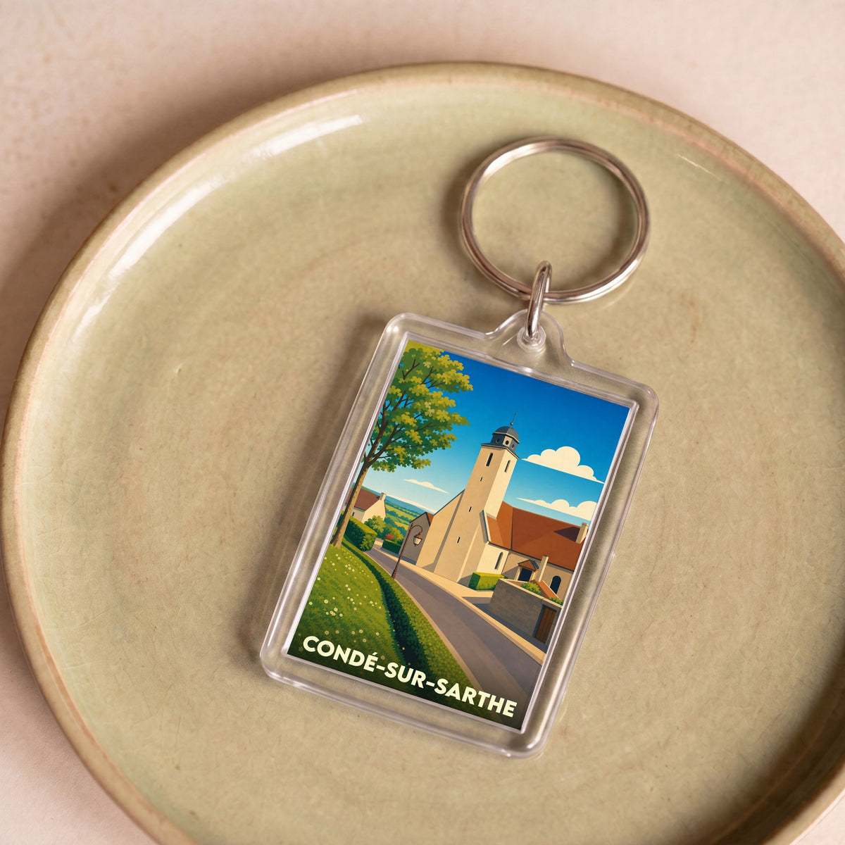 Porte-clés souvenir de la ville de Condé-sur-Sarthe avec une illustration stylisée.