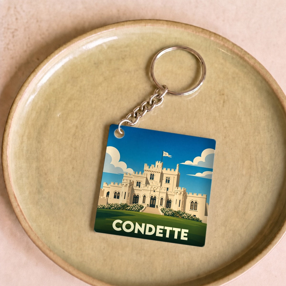 Porte-clés souvenir de la ville de Condette avec une illustration stylisée de son château.