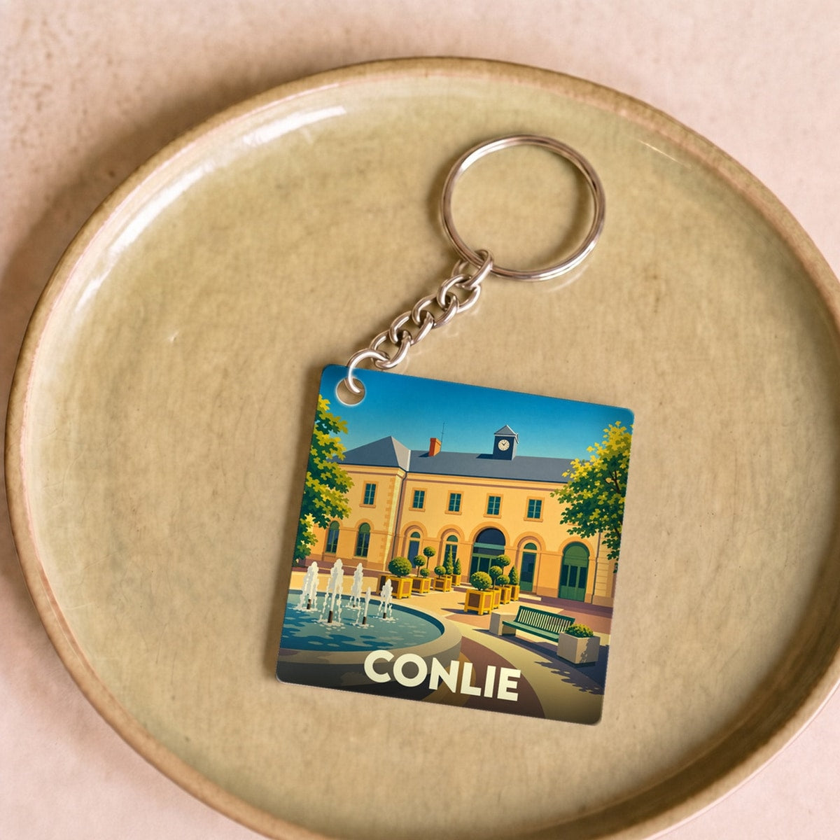 Porte-clés souvenir de la ville de Conlie avec une illustration stylisée.