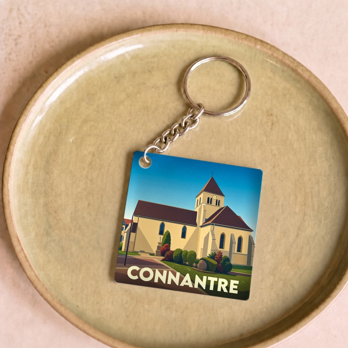 Porte-clés souvenir de la ville de Connantre avec une illustration stylisée de son église.