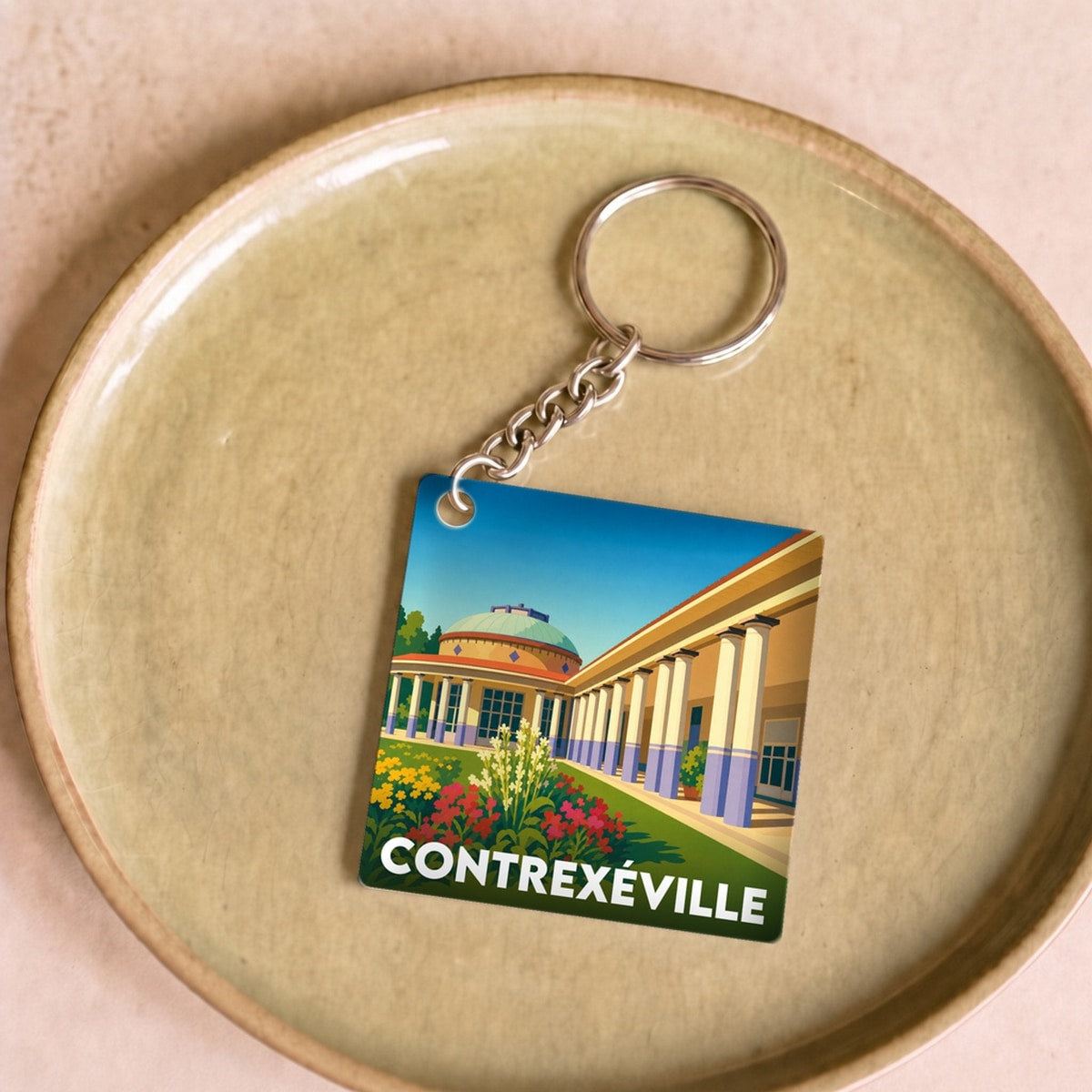 Porte-clés souvenir de la ville de Contrexéville avec une illustration stylisée.