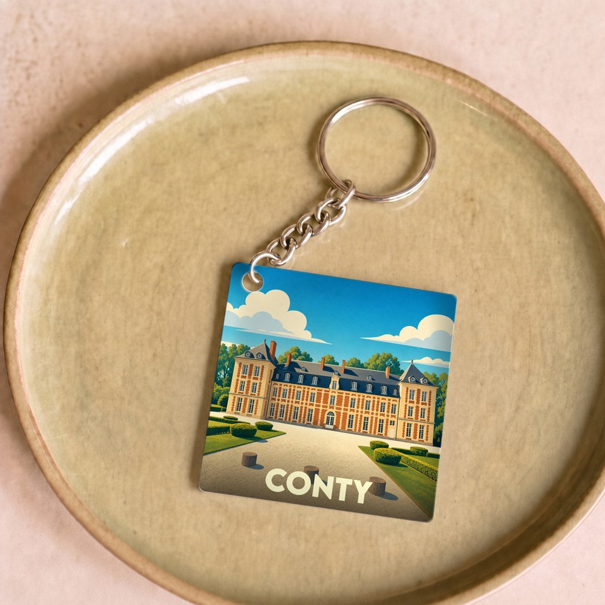 Porte-clés souvenir de la ville de Conty avec une illustration stylisée de son château.