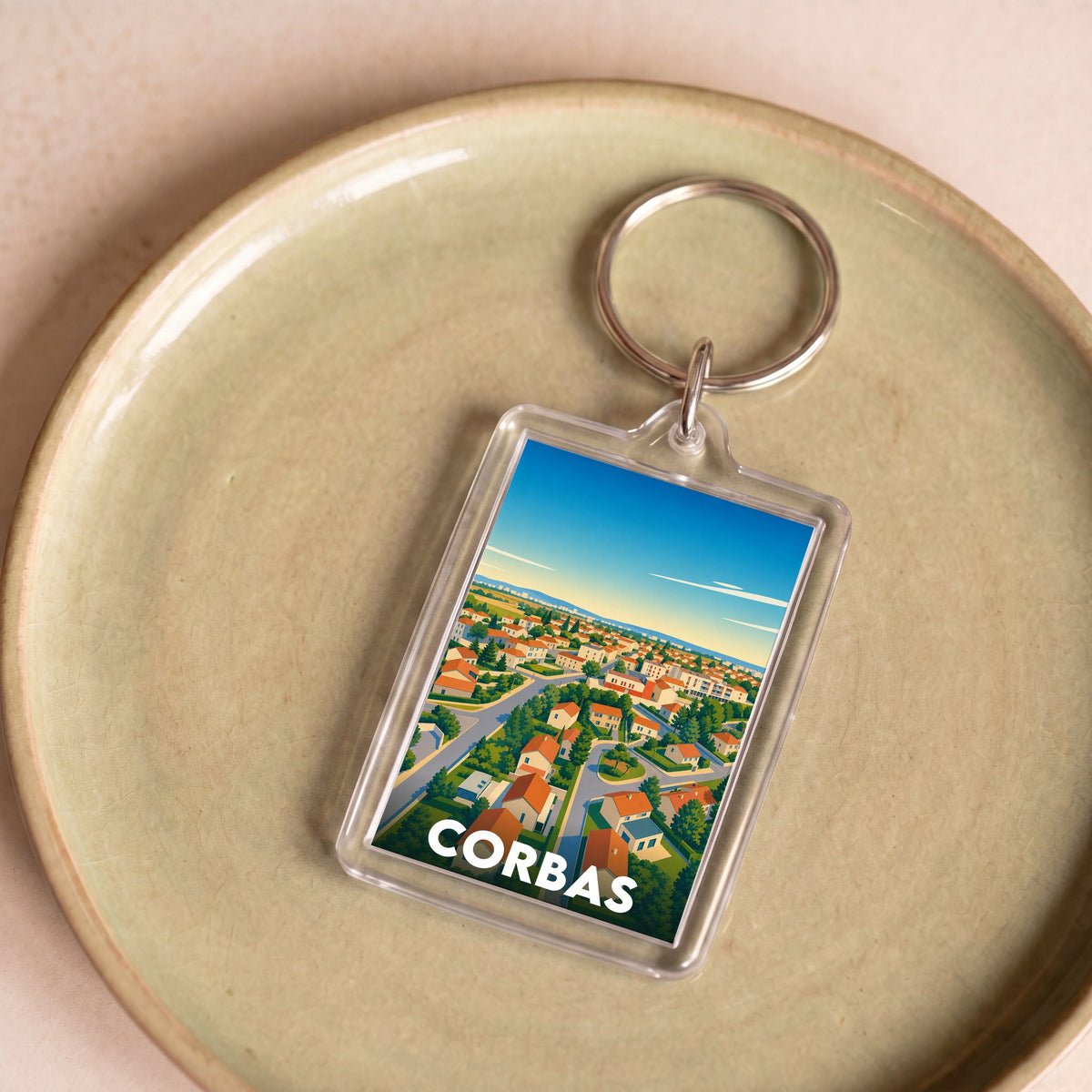 Porte-clés souvenir de la ville de Corbas avec une illustration stylisée vue du ciel.