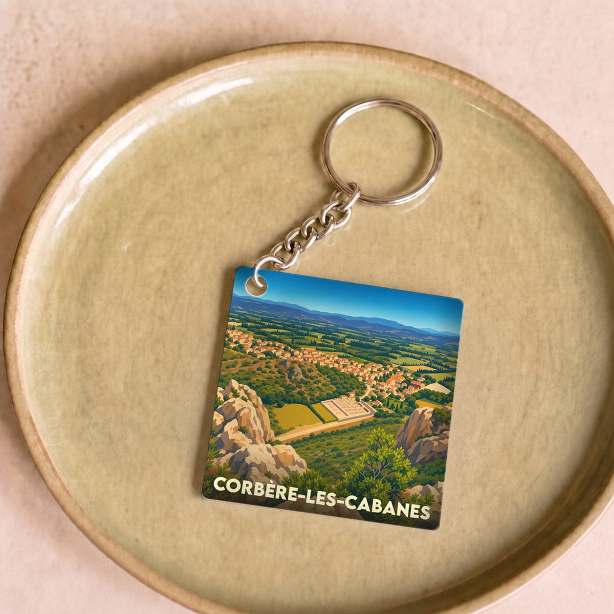Porte-clés souvenir de la ville de Corbère-les-Cabanes avec une illustration stylisée.