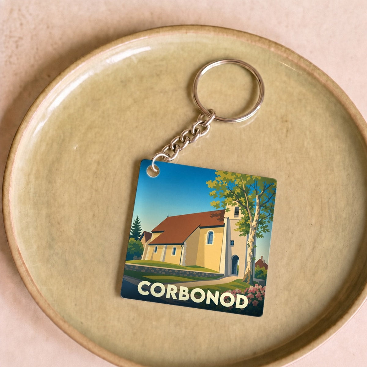 Porte-clés souvenir de la ville de Corbonod avec une illustration stylisée de son église.
