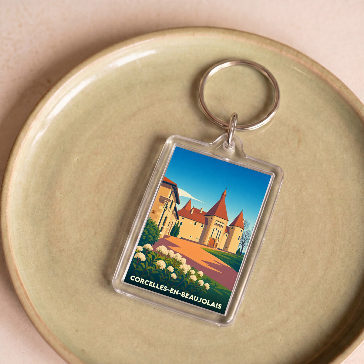 Porte-clés souvenir de Corcelles-en-Beaujolais orné d'une illustration stylisée de son château.