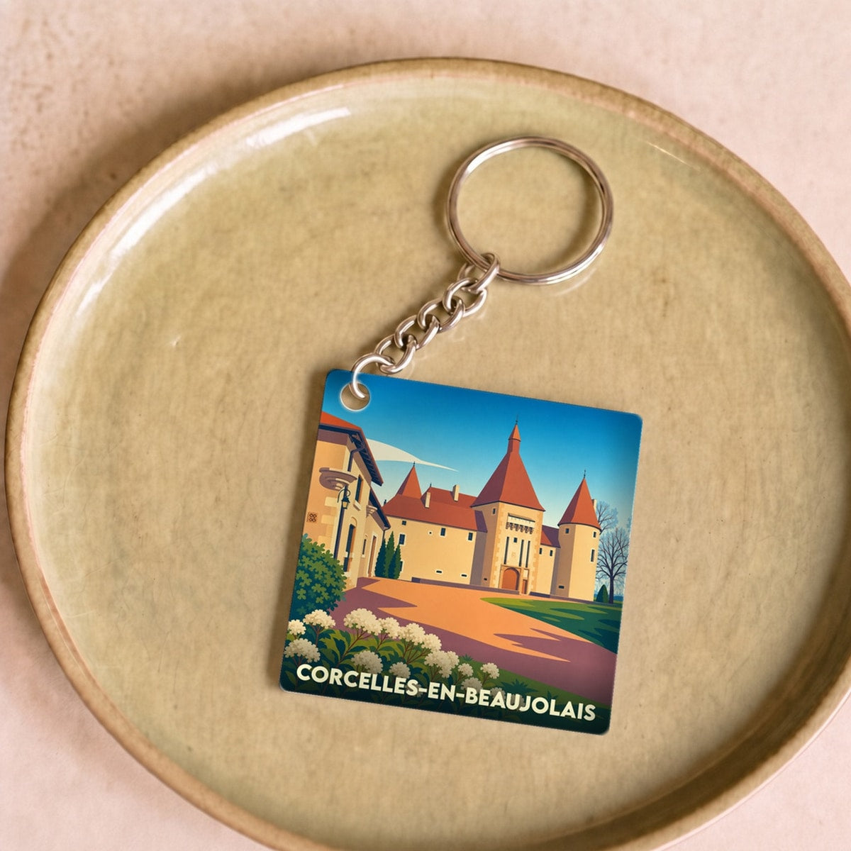 Porte-clés souvenir de Corcelles-en-Beaujolais orné d'une illustration stylisée de son château.