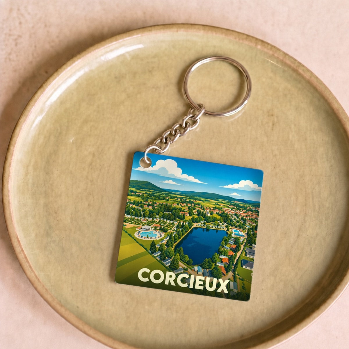 Porte-clés souvenir de la ville de Corcieux avec une illustration stylisée.