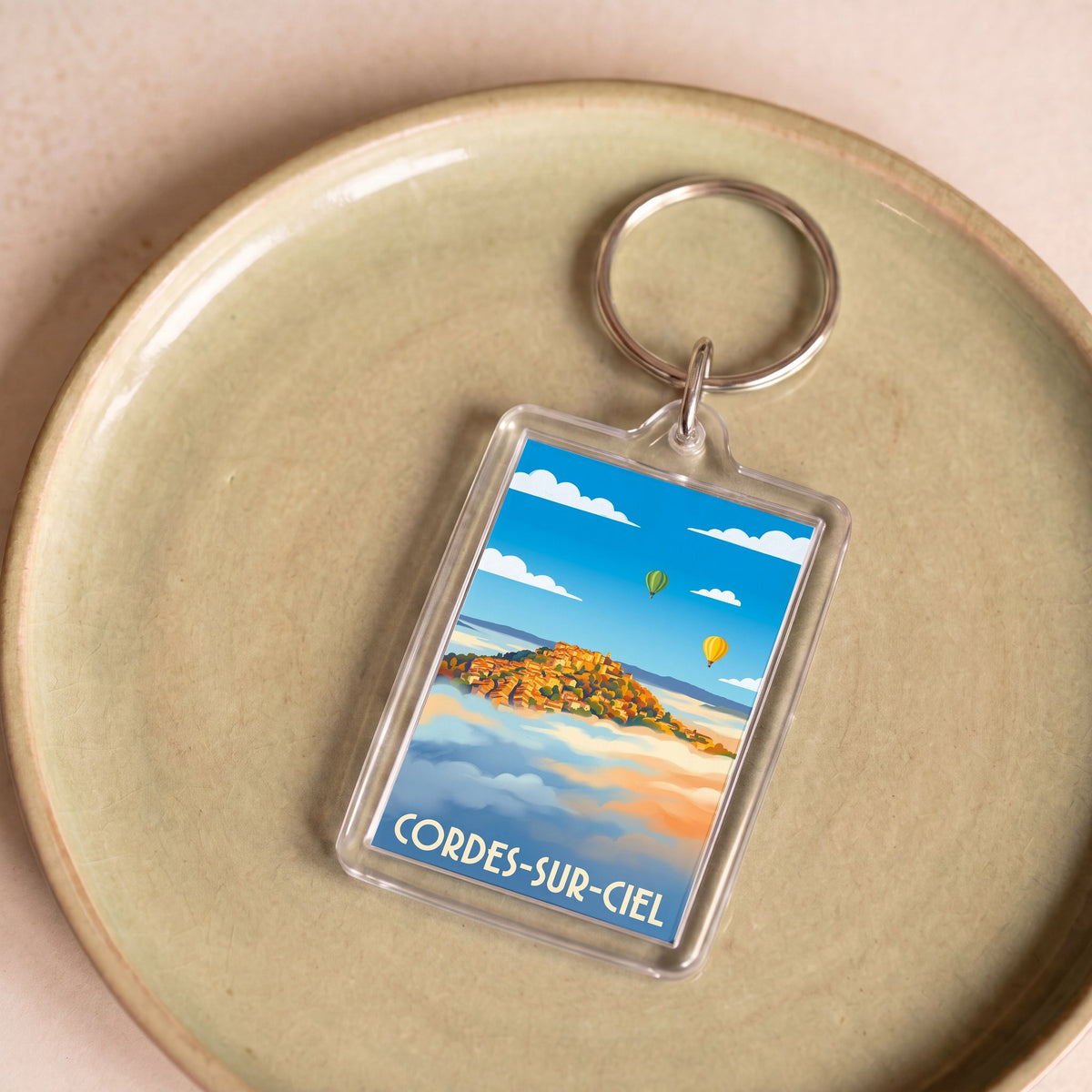 Porte-clés souvenir de la ville de Cordes-sur-Ciel avec une illustration stylisée.