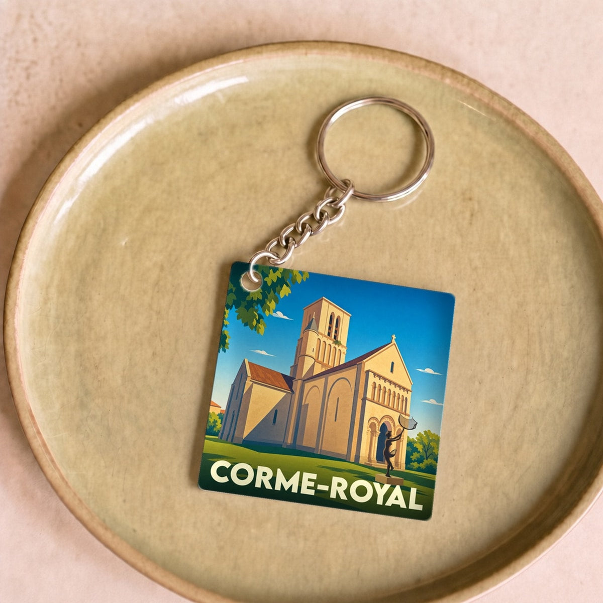 Porte-clés souvenir de la ville de Corme-Royal avec une illustration stylisée de son église.