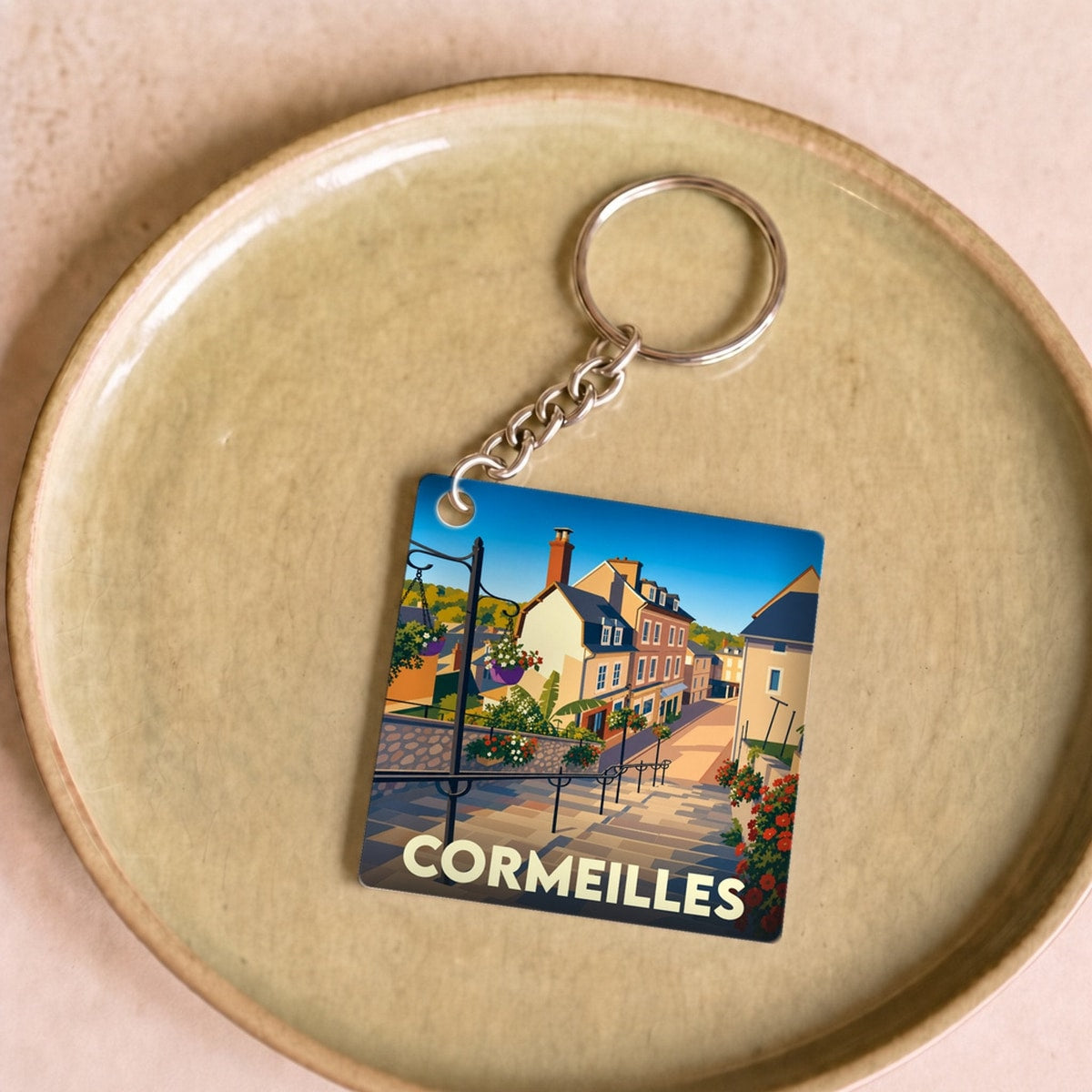 Porte-clés souvenir de la ville de Cormeilles avec une illustration stylisée.