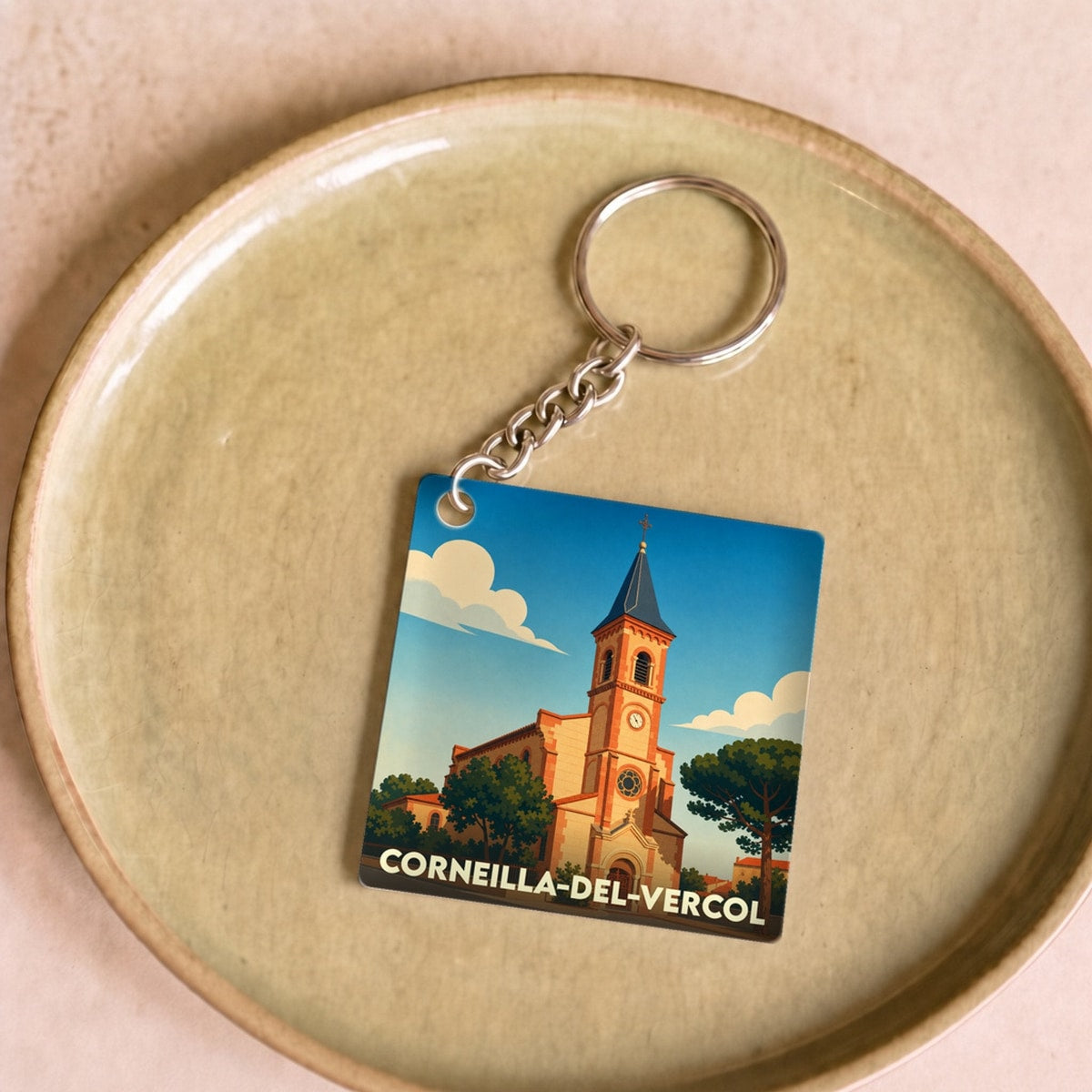 Porte-clés souvenir de la ville de Corneilla-del-Vercol avec une illustration stylisée de son église.