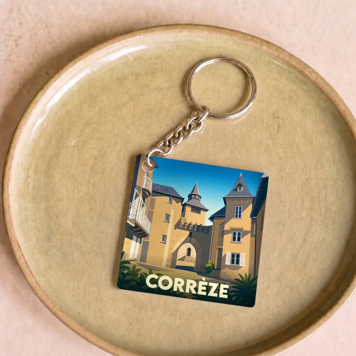 Porte-clés souvenir de la ville de Corrèze avec une illustration stylisée.