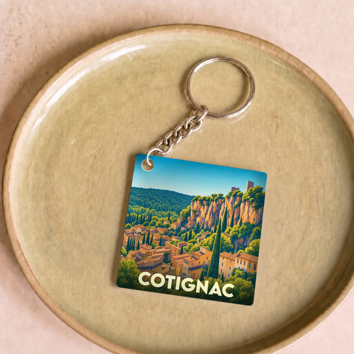 Porte-clés souvenir de la ville de Cotignac avec une illustration stylisée.