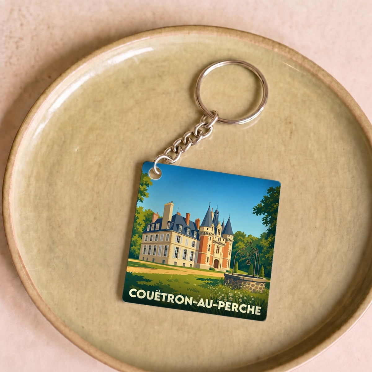 Porte-clés souvenir de la ville de Couëtron-au-Perche avec une illustration stylisée de son château.