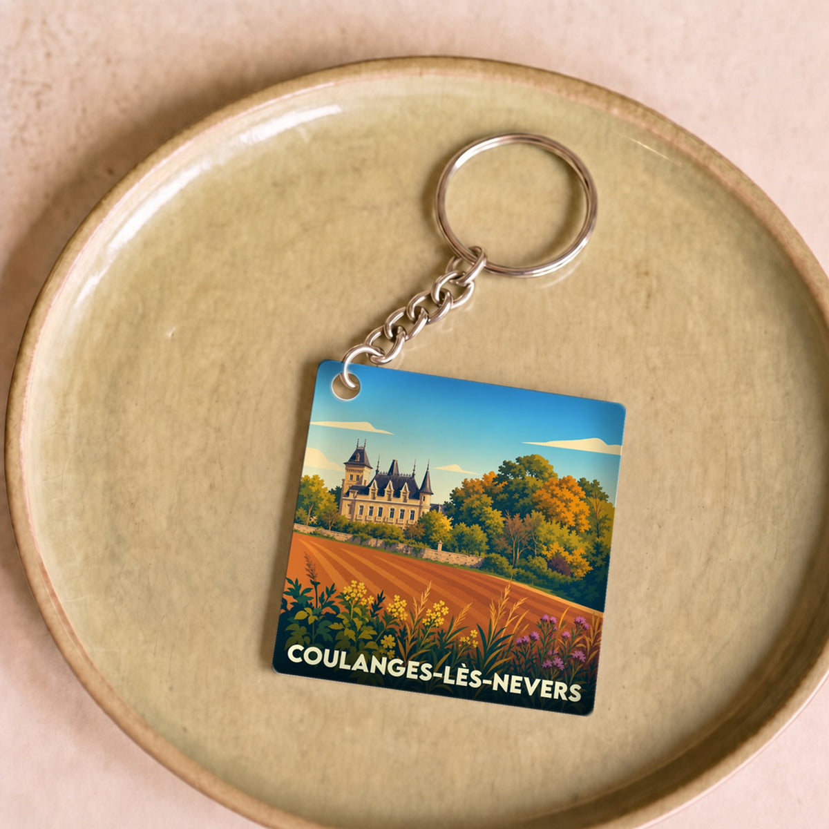 Porte-clés souvenir de la ville de Coulanges-lès-Nevers avec une illustration stylisée.