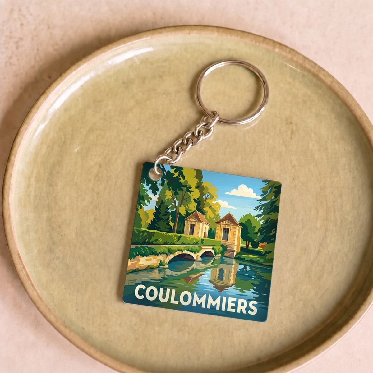 Porte-clés souvenir de la ville de Coulommiers avec une illustration stylisée.
