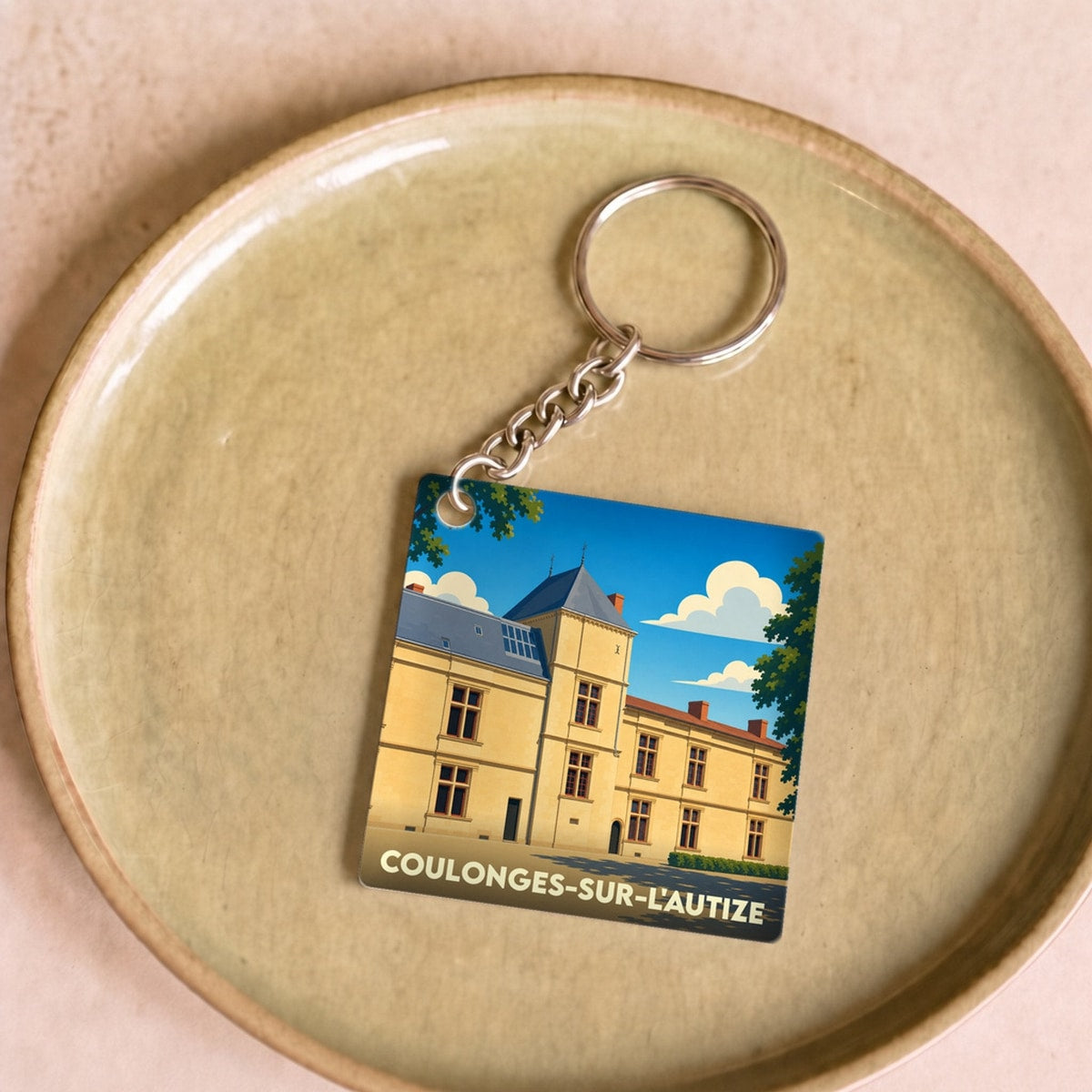 Porte-clés souvenir de la ville de Coulonges-sur-l'Autize avec une illustration stylisée de son château.