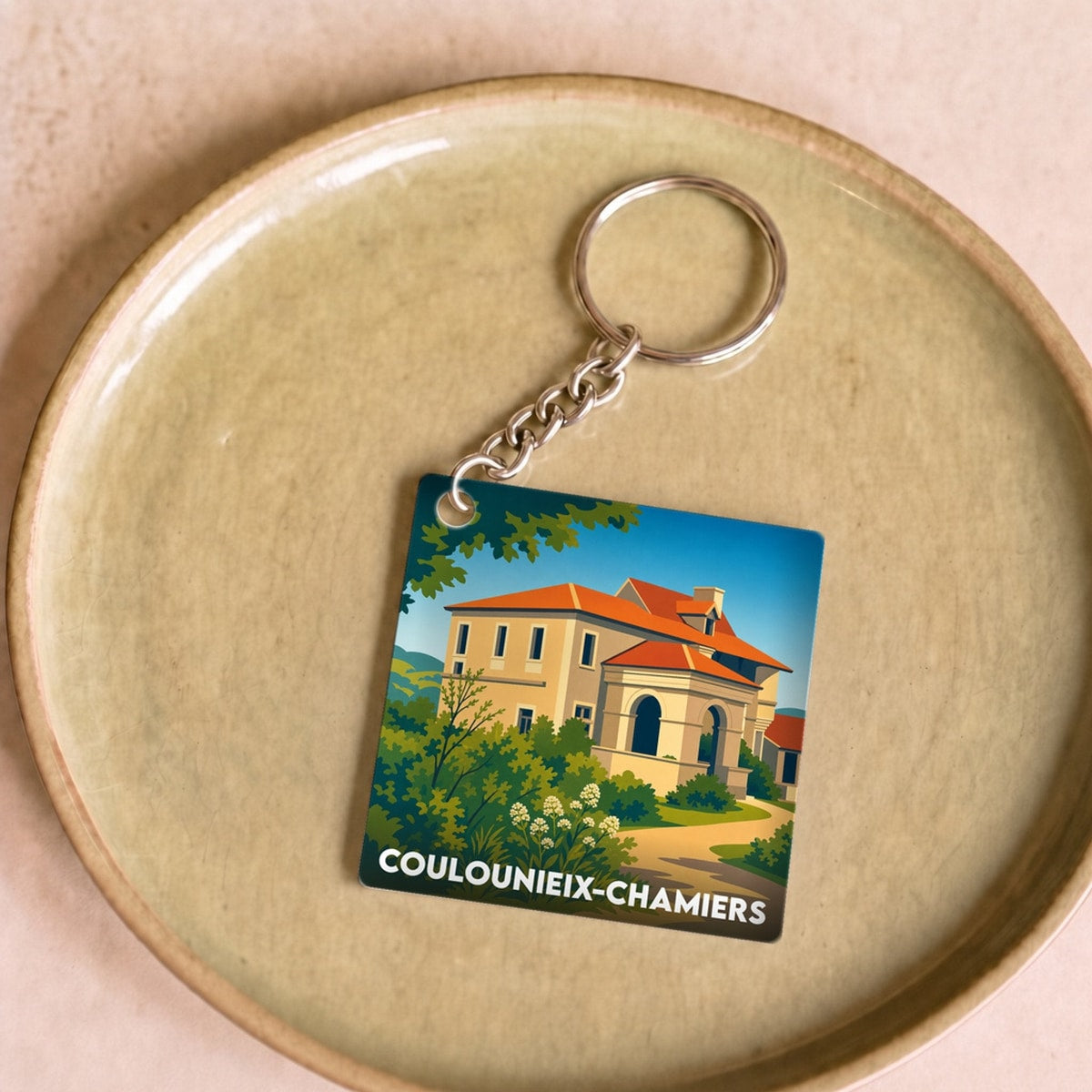 Porte-clés souvenir de la ville de Coulounieix-Chamiers avec une illustration stylisée.