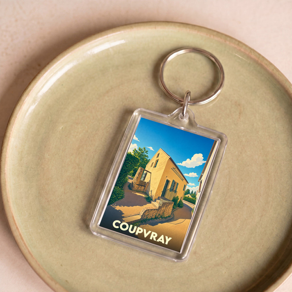 Porte-clés souvenir de la ville de Coupvray avec une illustration stylisée de la maison de Louis Braille.