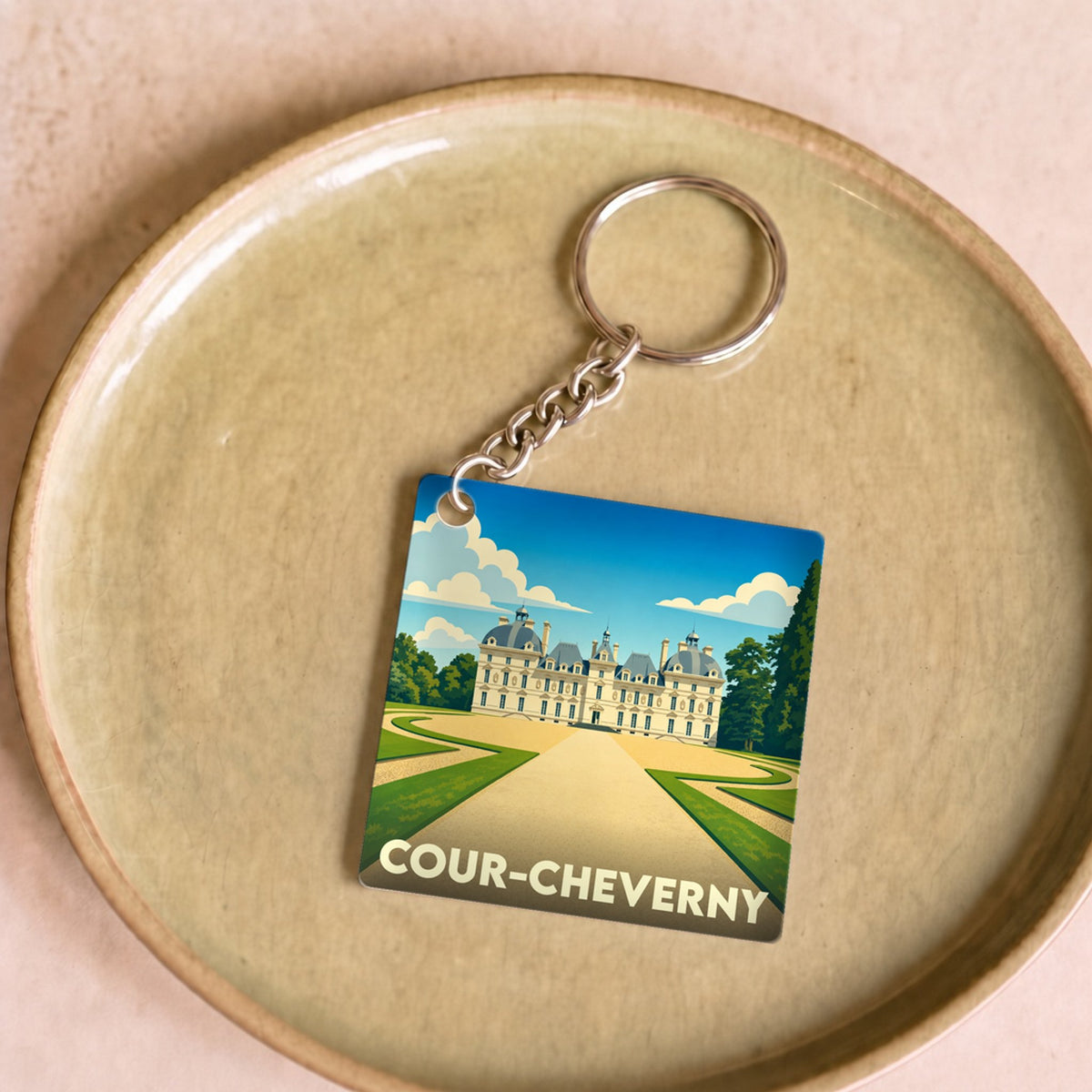 Porte-clés souvenir de la ville de Cour-Cheverny avec une illustration stylisée de son château.