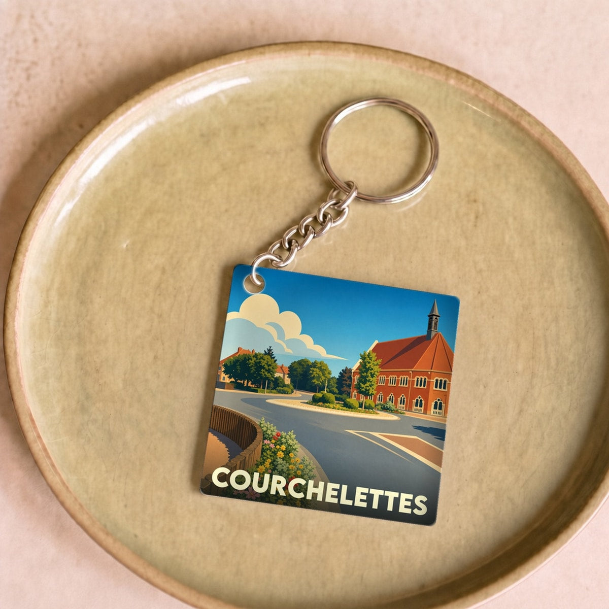Porte-clés souvenir de la ville de Courchelettes avec une illustration stylisée.