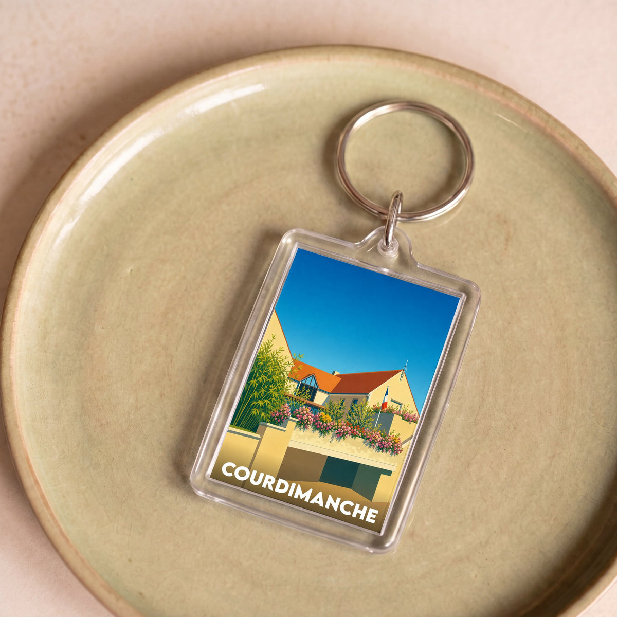 Porte-clés souvenir de la ville de Courdimanche avec une illustration stylisée de la mairie.