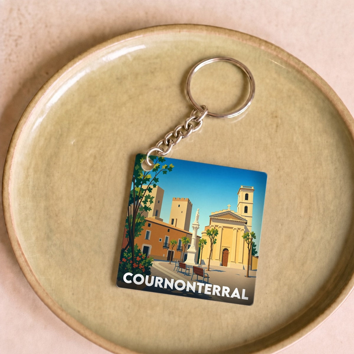 Porte-clés souvenir de la ville de Cournonterral avec une illustration stylisée.