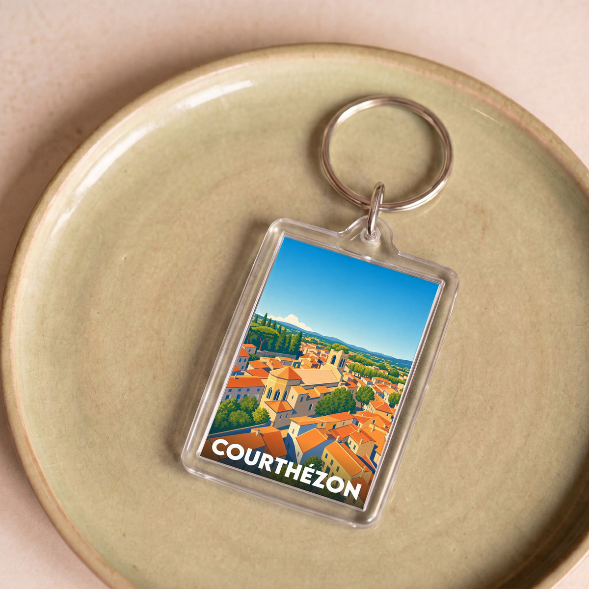 Porte-clés souvenir de la ville de Courthézon avec une illustration stylisée.