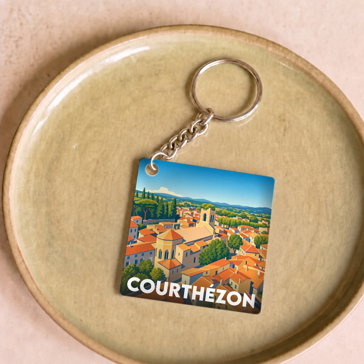 Porte-clés souvenir de la ville de Courthézon avec une illustration stylisée.